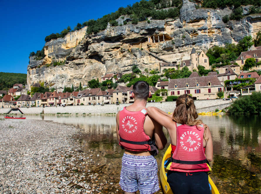 een koppel in een kano kijkt uit over La Roque-Gageac tijdens de kanotocht Carsac Beynac